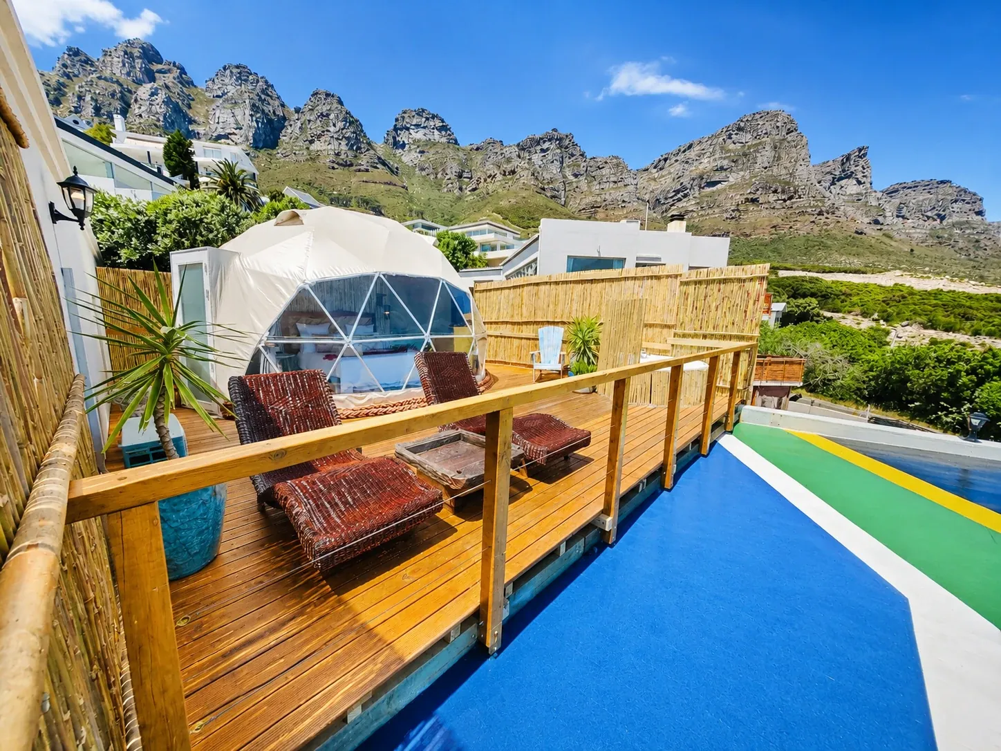 Geodesic dome on a raised timber deck below the mountains